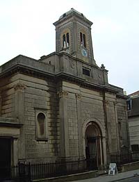 Shows a photograph of St Andrew's Church, a building with a clear Mediterranean influence. It has a clock tower and an arched door.